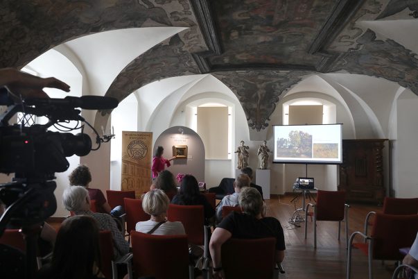 Kustosz Maria Stopyra prezentuje nowy muzealny nabytek obraz W. Maleckiego "Niedziela"