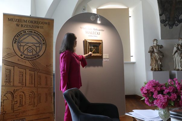 Kustosz Maria Stopyra prezentuje nowy muzealny nabytek obraz W. Maleckiego "Niedziela"