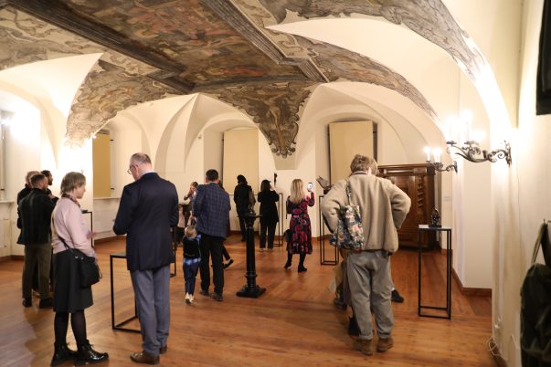 Wernisaż wystawy rzeźb Karoliny Koch "Odbicie" . Uczestnicy oglądający rzeźby na muzealnym refktarzu