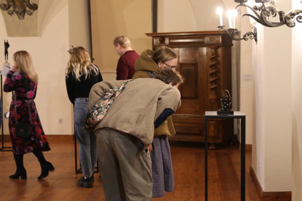 Wernisaż wystawy rzeźb Karoliny Koch "Odbicie" . Uczestnicy oglądający rzeźby na muzealnym refktarzu